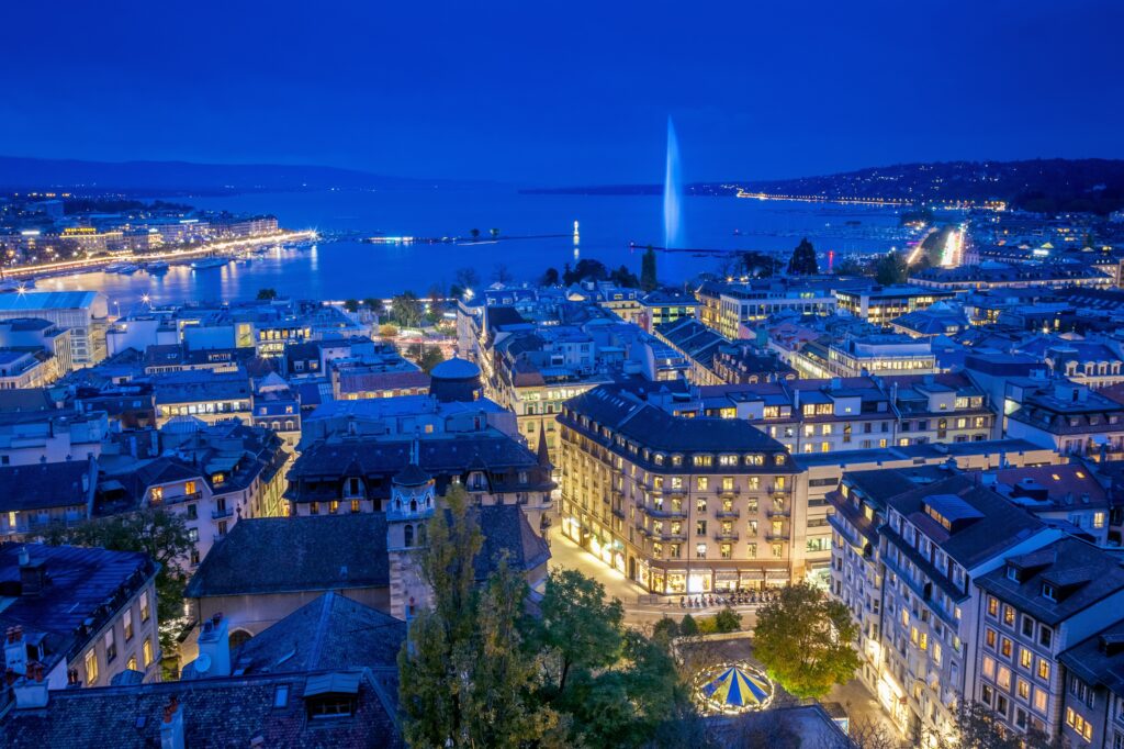 Aerial view of Geneva City center and Jet d’eau by night on World ...